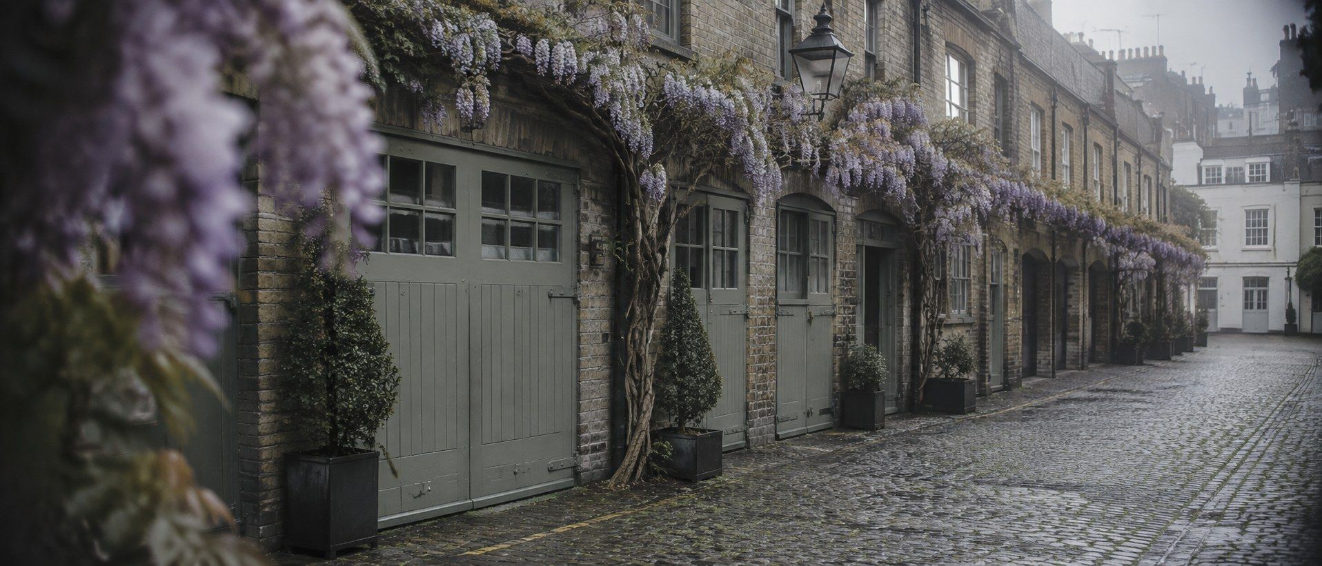 Cobbled Belgravia mews with painted former stable doors in soft morning haze