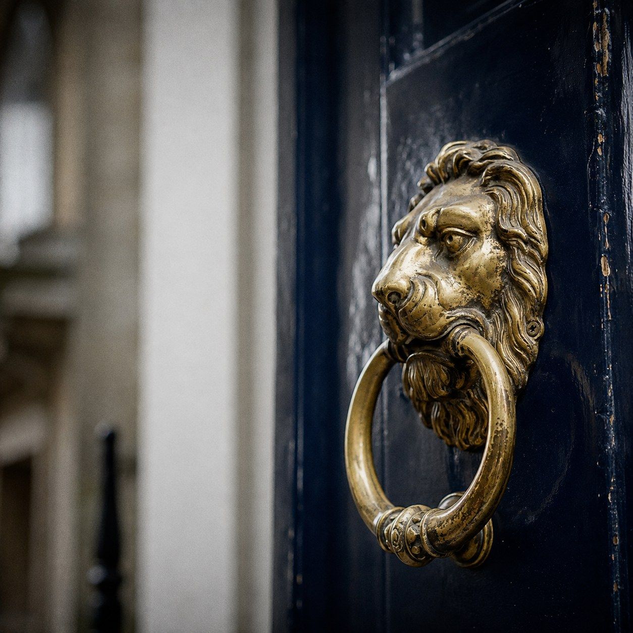 Brass door knocker on the glossy navy front door of a Georgian townhouse